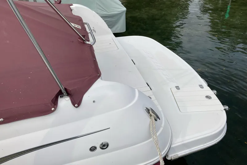 Slide: The Image of 2005 Ebbtide 2400 Fun Cruiser DC boat with maroon cover, docked on calm water. - 7