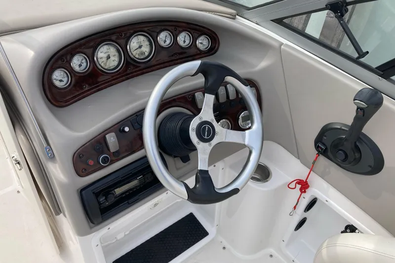 Slide: The Image of 2005 Ebbtide 2400 Fun Cruiser DC dashboard with steering wheel and control panel. - 8