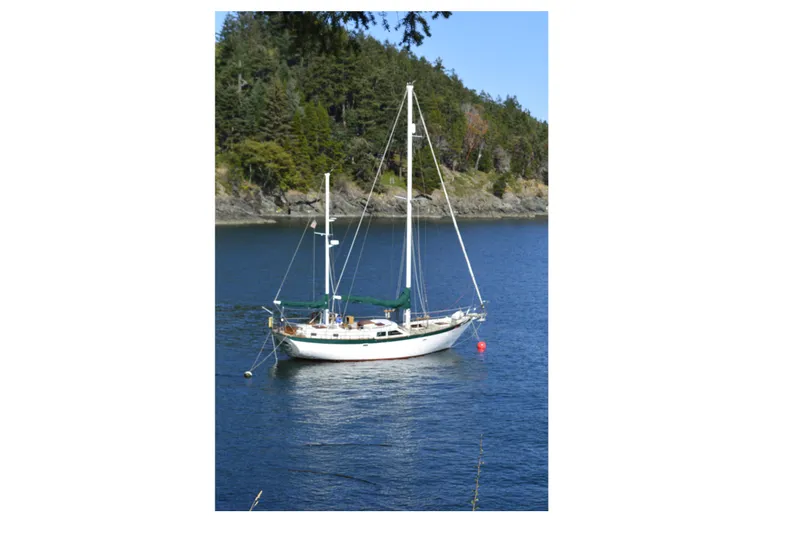 The Image of Sailboat Hardin 45 Voyager 1981 anchored in scenic bay with forested background. - 1