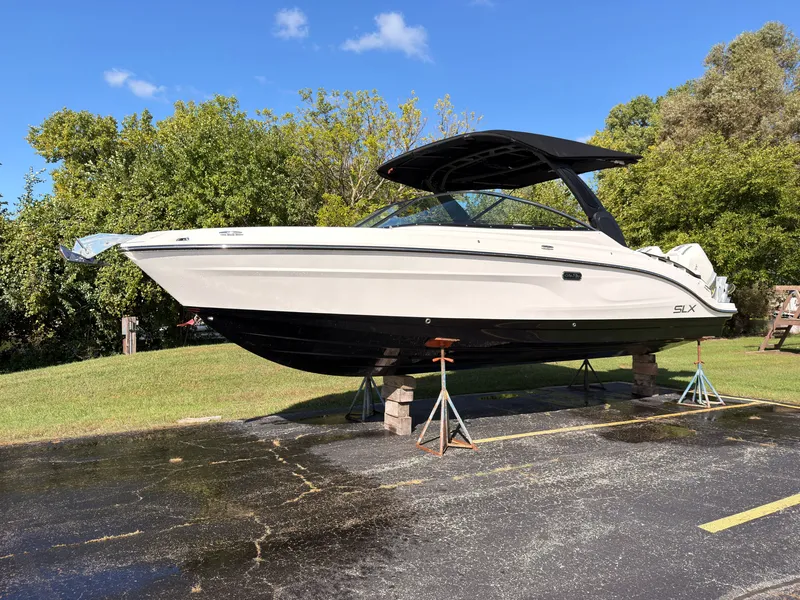 The Image of A 2026 Sea Ray SLX 280 Outboard is parked on a lot, surrounded by trees. - 0