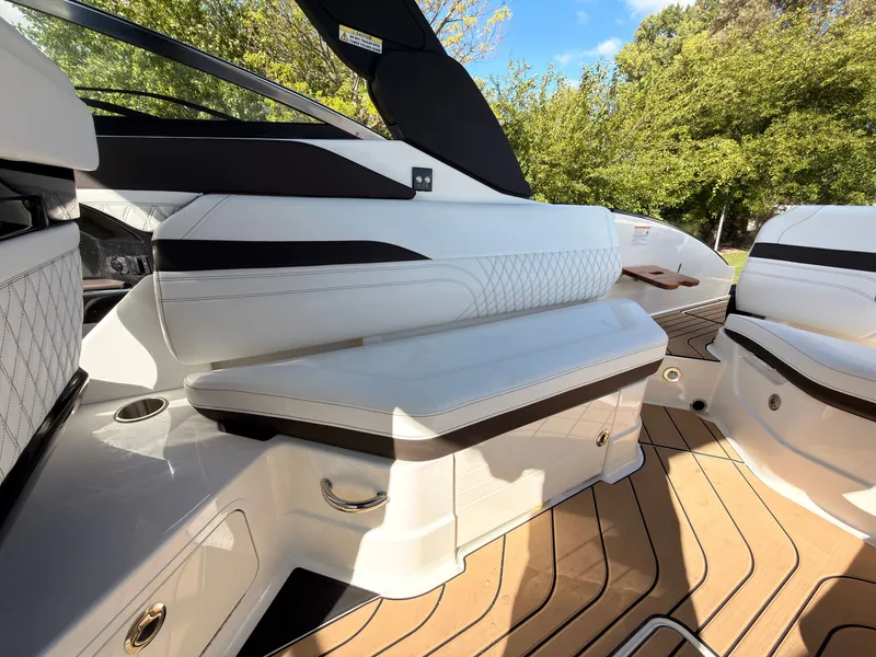 Slide: The Image of The image shows the cockpit of a Sea Ray SLX 280 Outboard with sleek white seating and wood flooring. - 49