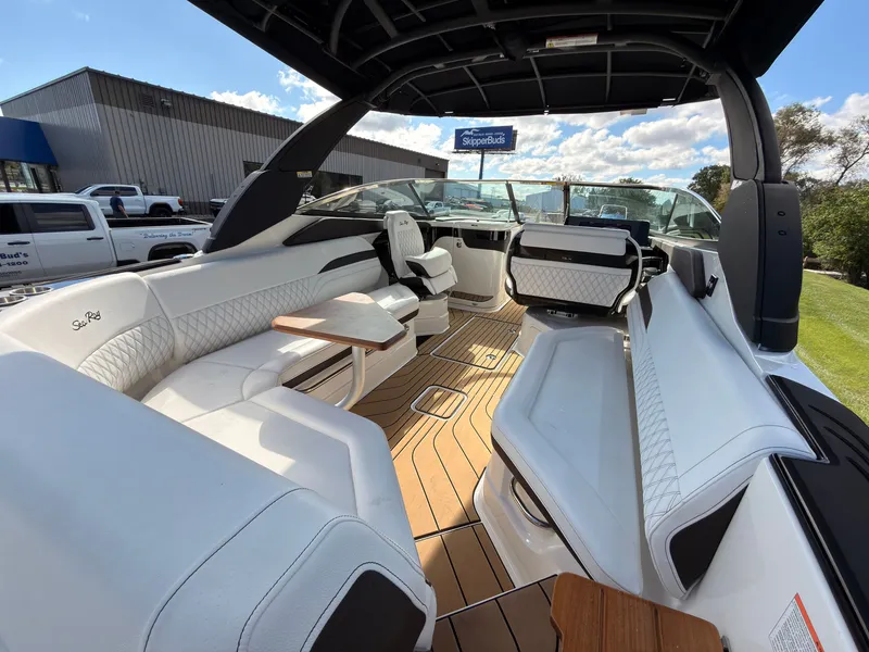 Slide: The Image of The image shows the spacious cockpit of a 2026 Sea Ray SLX 280 Outboard with sleek white seating and wood flooring. - 36