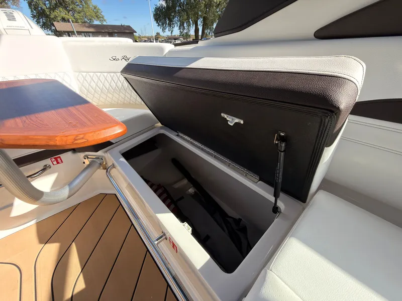 Slide: The Image of The 2026 Sea Ray SLX 280 Outboard features a sleek storage compartment with a wooden table and upholstery. - 44