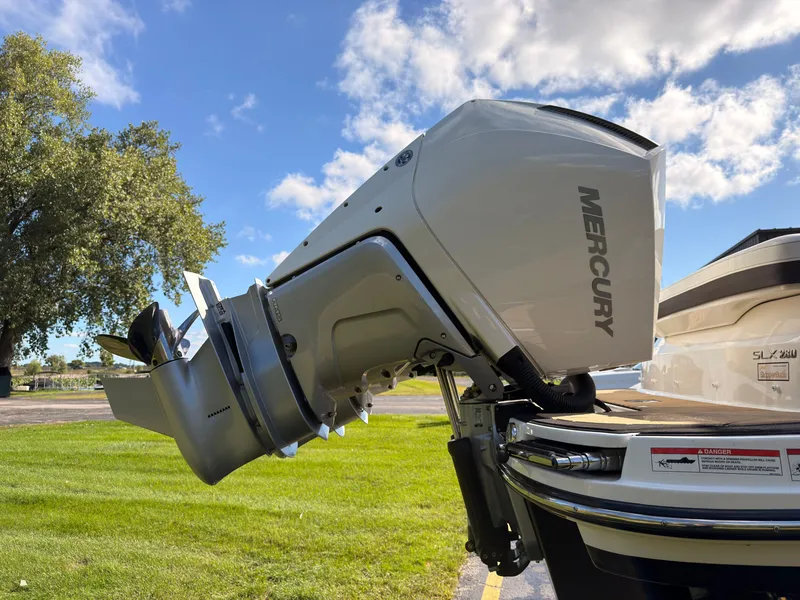 Slide: The Image of A Mercury outboard motor is attached to a Sea Ray SLX 280 boat, positioned on grass. - 13