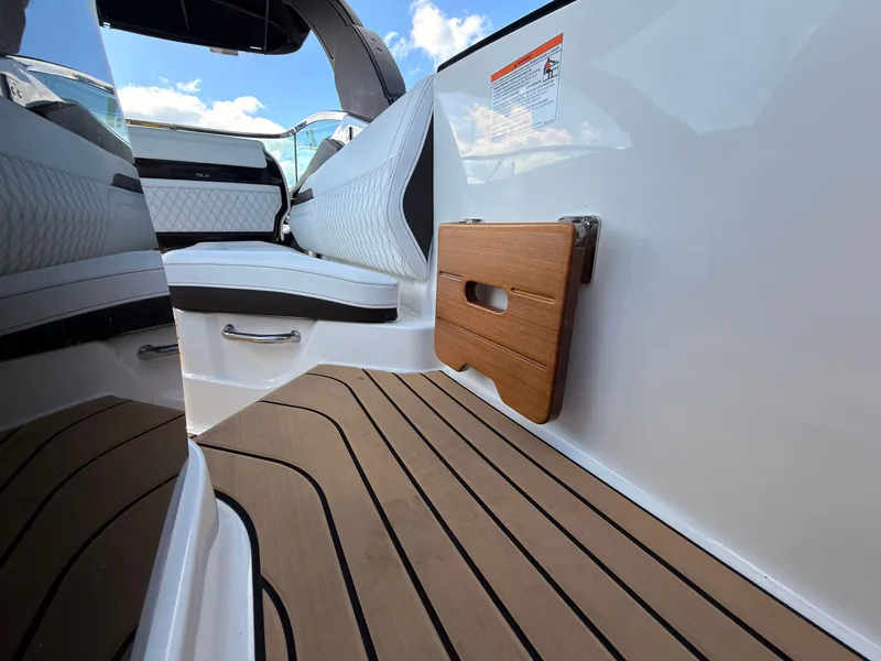 Slide: The Image of The image shows the interior of a Sea Ray SLX 280 Outboard with sleek seating and wood flooring. - 34