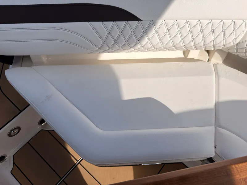 Slide: The Image of The image shows a white, cushioned seating area with a quilted pattern on a boat. - 38