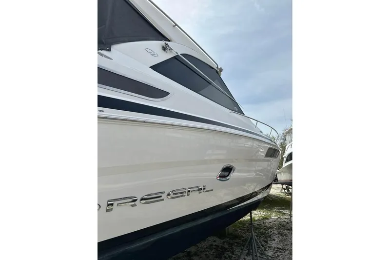 Slide: The Image of 2016 Regal 35 Sport Coupe boat side view with sleek design and branding. - 6