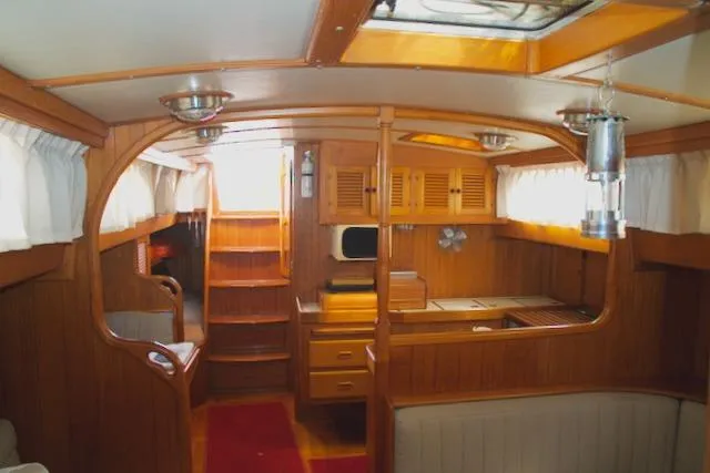 Slide: The Image of Interior of 1986 Passport 42 sailboat with wooden cabinetry and cozy seating area. - 15