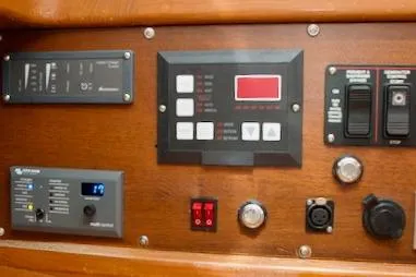 Slide: The Image of Control panel of a 1986 Passport 42 yacht with various switches and displays. - 19