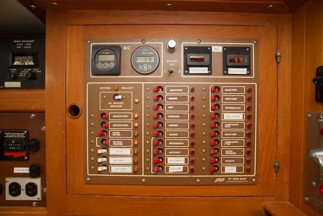 Slide: The Image of Electrical control panel on a 1986 Passport 42 boat, featuring switches and meters. - 21
