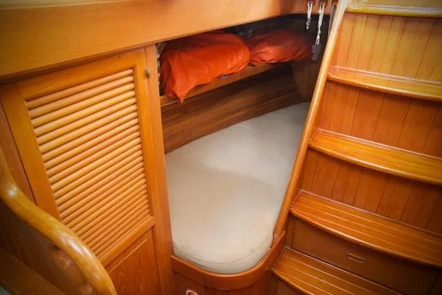 Slide: The Image of Cozy wooden cabin interior of 1986 Passport 42 sailboat with bed and storage. - 23