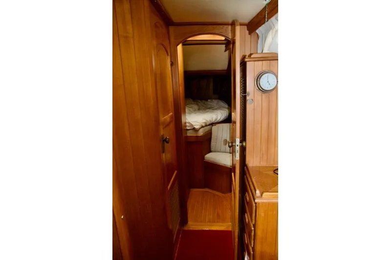 Slide: The Image of Cozy wooden interior of 1986 Passport 42 sailboat cabin with bed and clock. - 26