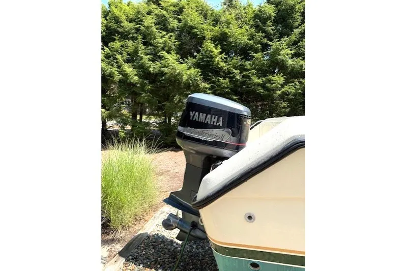 Slide: The Image of 2001 Pursuit 2470 Center Console boat interior with storage compartments and Yamaha V250 engine. - 11