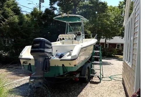 Slide: The Image of 2001 Pursuit 2470 Center Console boat with Yamaha outboard motor, surrounded by greenery. - 12