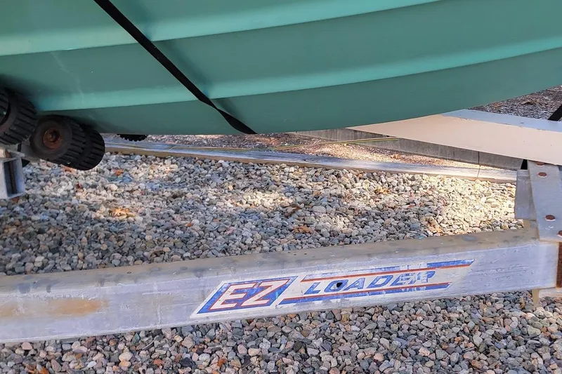 Slide: The Image of 2001 Pursuit 2470 Center Console boat under a protective cover, showcasing its canopy and console. - 15