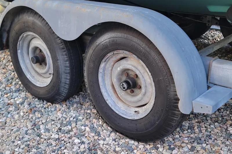 Slide: The Image of 2001 Pursuit 2470 Center Console on EZ Loader trailer, resting on gravel. - 16