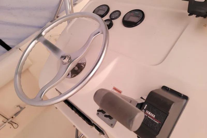 Slide: The Image of 2001 Pursuit 2470 Center Console boat interior with white seating and console details. - 18