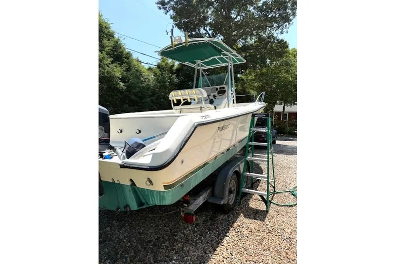 Slide: The Image of 2001 Pursuit 2470 Center Console boat on trailer, parked outdoors. - 25