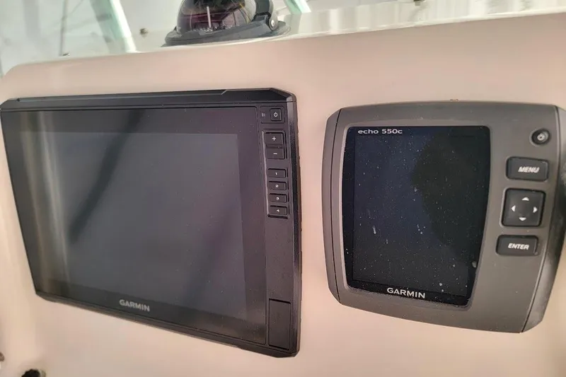 Slide: The Image of 2001 Pursuit 2470 Center Console boat dashboard with steering wheel and navigation equipment. - 4