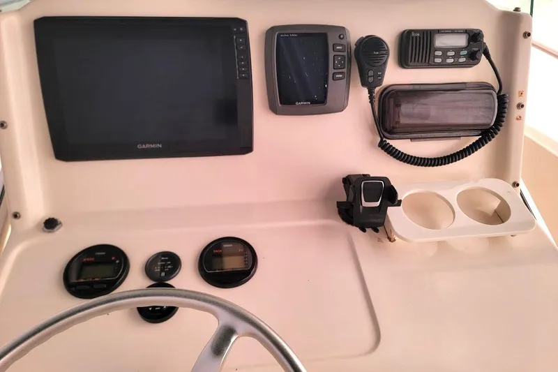 Slide: The Image of 2001 Pursuit 2470 Center Console boat covered on a trailer in a yard. - 8