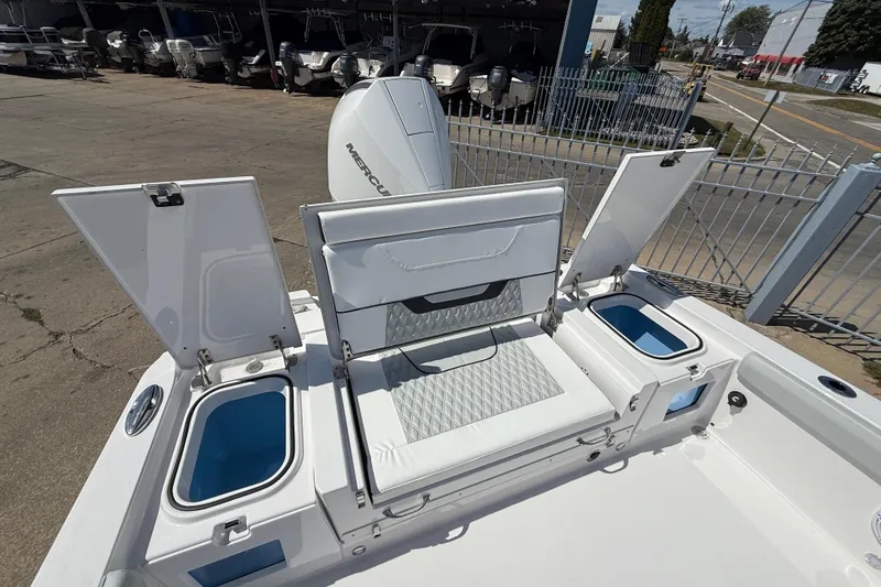 Slide: The Image of 2026 Blackfin 242 HB boat with open storage compartments and seating, docked outdoors. - 10