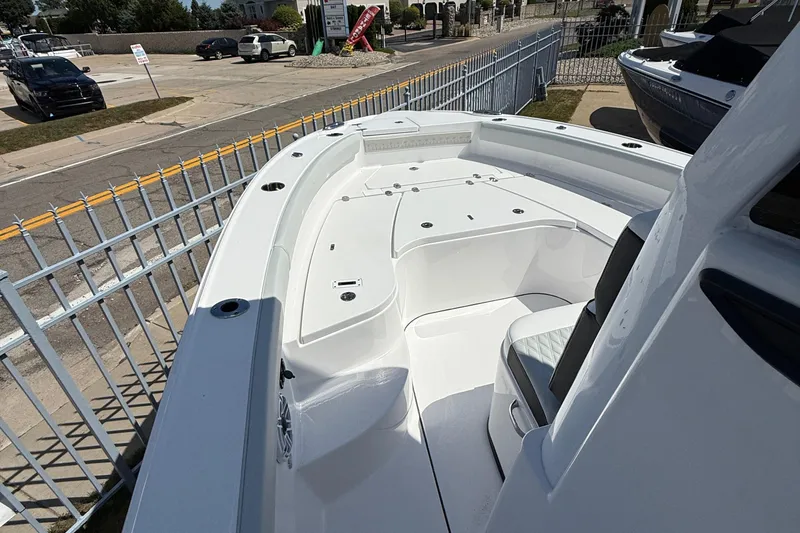 Slide: The Image of 2026 Blackfin 242 HB boat, white deck, parked near a fence in a marina. - 20