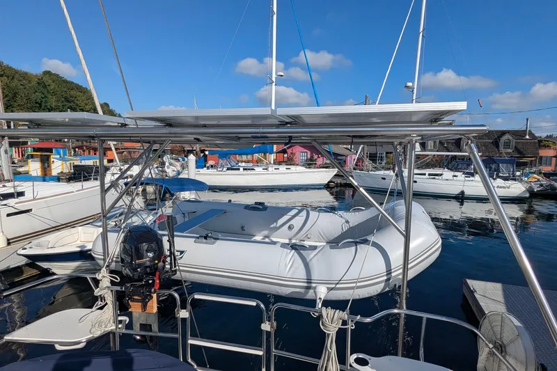 Slide: The Image of Sailboats docked at marina, featuring a 2003 Catalina 42 MkII with solar panels and inflatable dinghy. - 10