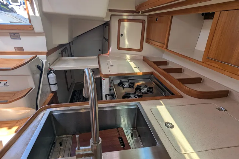 Slide: The Image of Interior of 2003 Catalina 42 MkII yacht kitchen with stove, sink, and wooden cabinetry. - 18