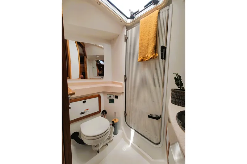 Slide: The Image of Bathroom interior of 2003 Catalina 42 MkII yacht, featuring a compact design with a shower and toilet. - 27