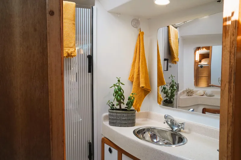 Slide: The Image of Bathroom interior of 2003 Catalina 42 MkII yacht with sink, mirror, and yellow towels. - 28