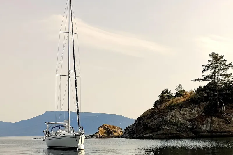 Slide: The Image of Catalina 42 MkII sailboat anchored near rocky shoreline, serene waters, 2003 model. - 5