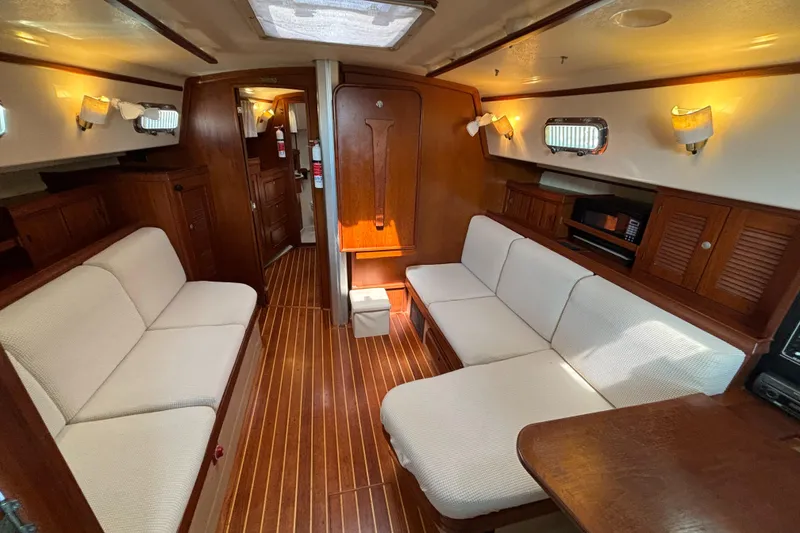 Slide: The Image of Interior of 1995 Island Packet 40 sailboat with cozy seating and wooden finishes. - 11
