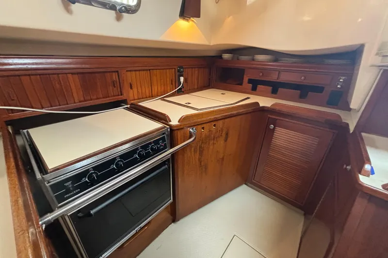 Slide: The Image of Galley kitchen in 1995 Island Packet 40 sailboat with wood cabinetry and stove. - 15