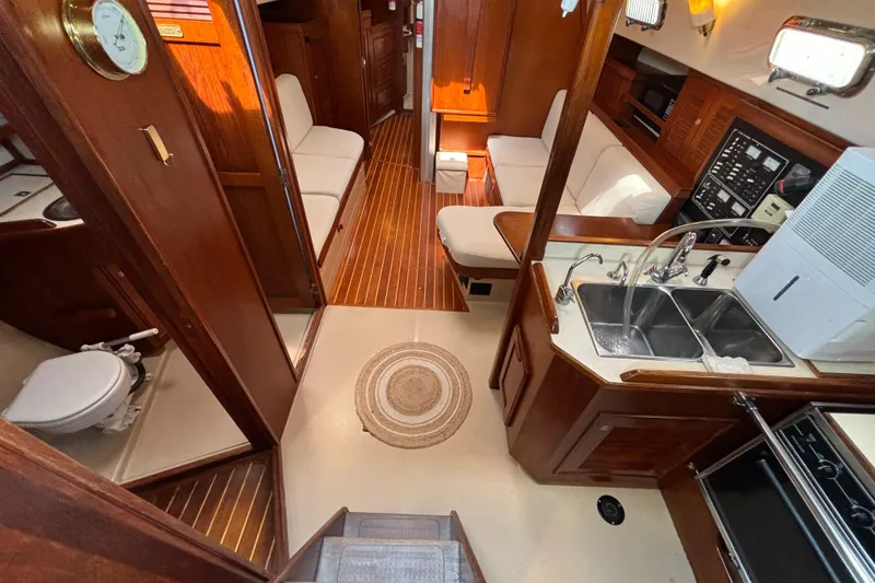 Slide: The Image of Interior of 1995 Island Packet 40 sailboat with wood finish and compact kitchen. - 2