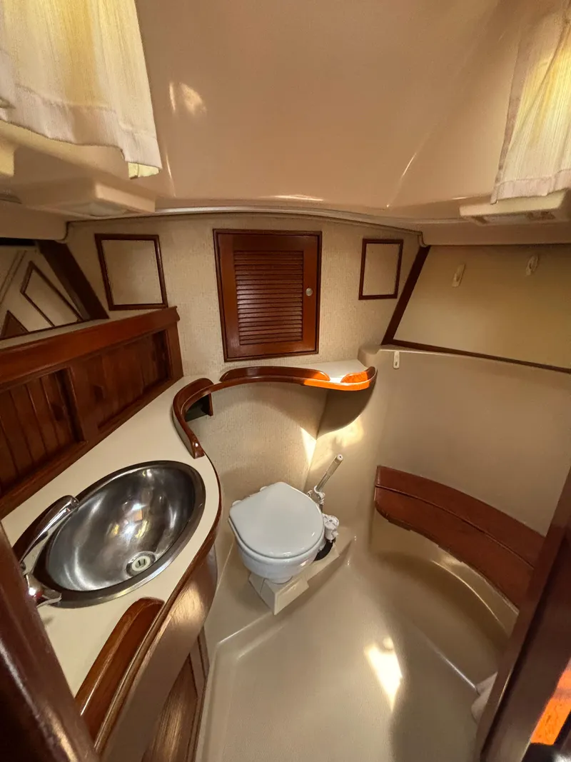Slide: The Image of 1995 Island Packet 40 yacht bathroom with sink, toilet, and wooden accents. - 22