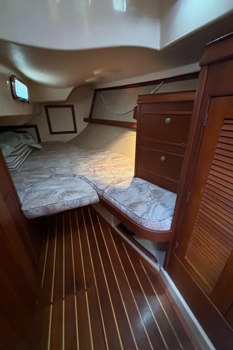 Slide: The Image of Cozy cabin interior of 1995 Island Packet 40 sailboat with wooden furnishings and bed. - 32