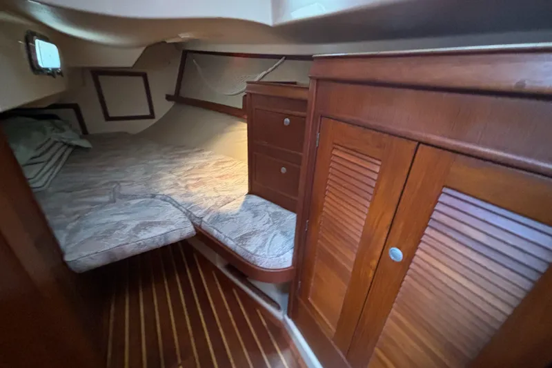 Slide: The Image of 1995 Island Packet 40 sailboat cabin with wooden interior and cozy sleeping area. - 33