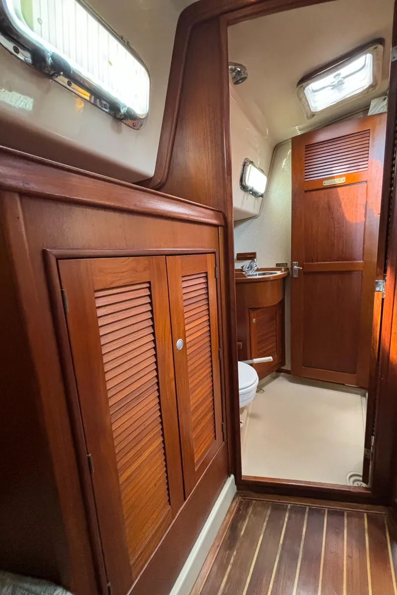 Slide: The Image of Interior of 1995 Island Packet 40 sailboat with wooden cabinetry and natural light. - 34