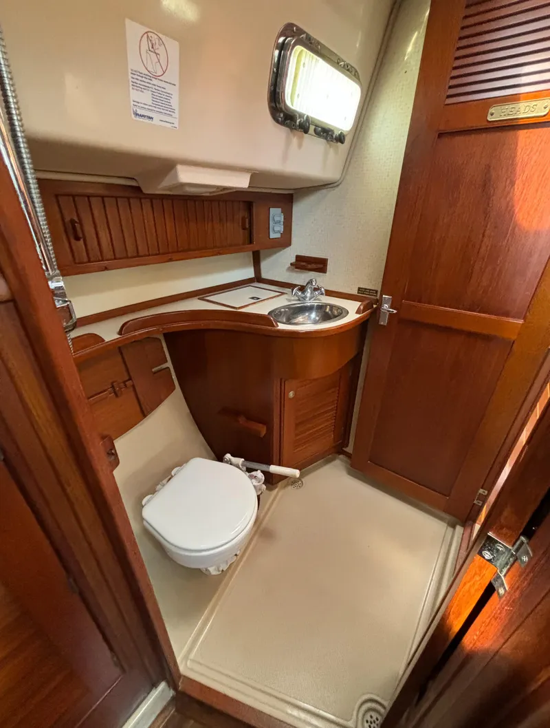 Slide: The Image of 1995 Island Packet 40 yacht bathroom with wooden cabinetry and compact design. - 35