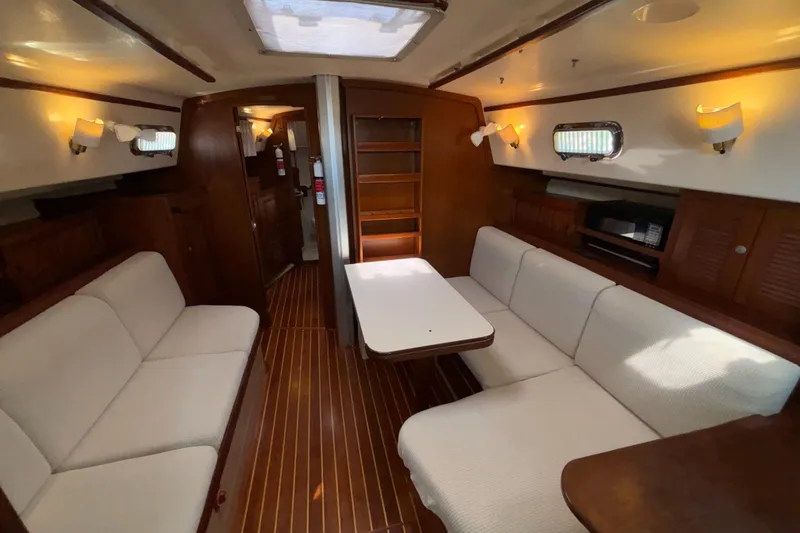 Slide: The Image of Interior of 1995 Island Packet 40 sailboat with cozy seating and wooden finishes. - 4