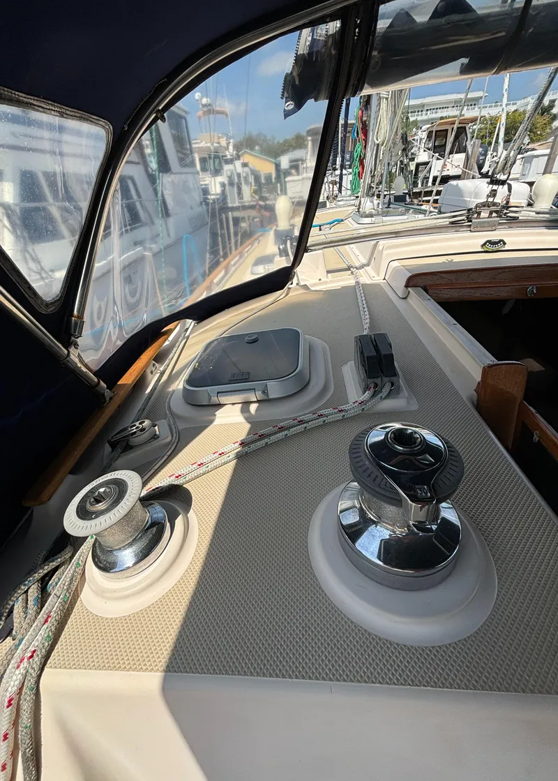 Slide: The Image of 1995 Island Packet 40 sailboat deck with winches and ropes in a marina setting. - 45