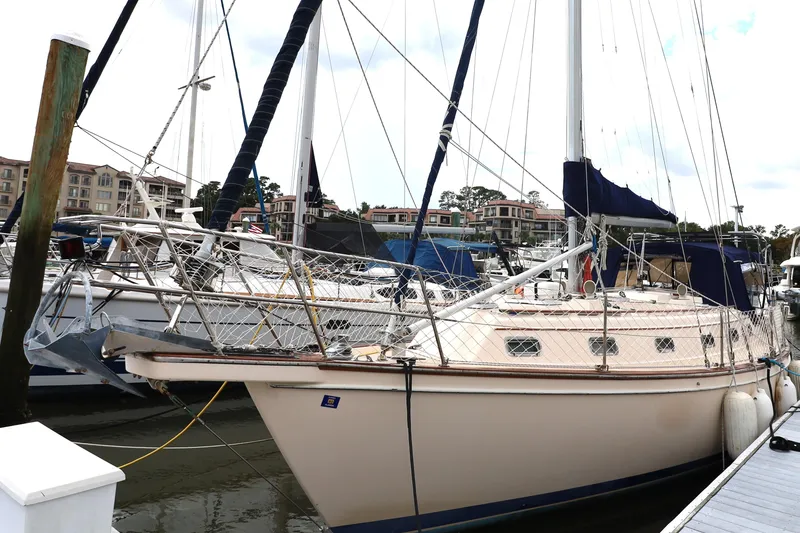 Slide: The Image of 1995 Island Packet 40 sailboat docked at marina, surrounded by other boats. - 60