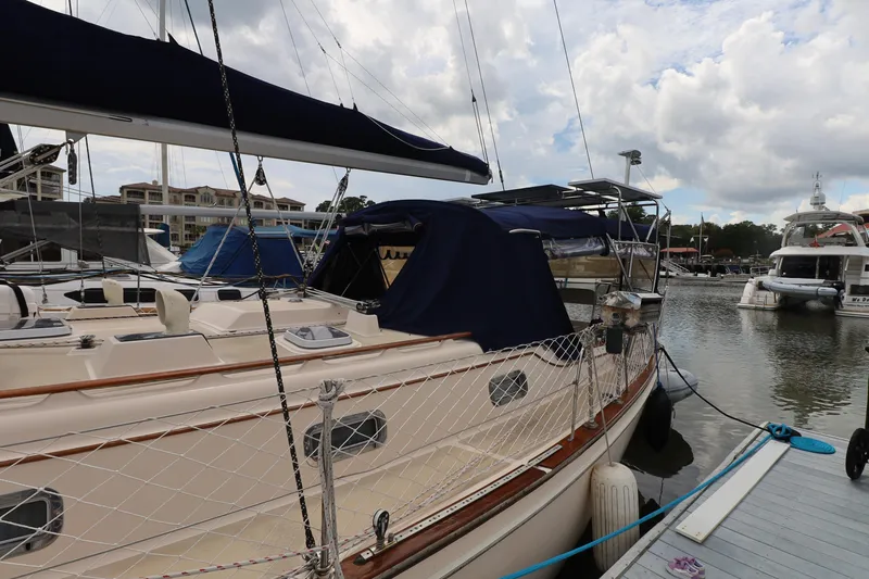Slide: The Image of 1995 Island Packet 40 sailboat docked at marina under cloudy sky. - 64