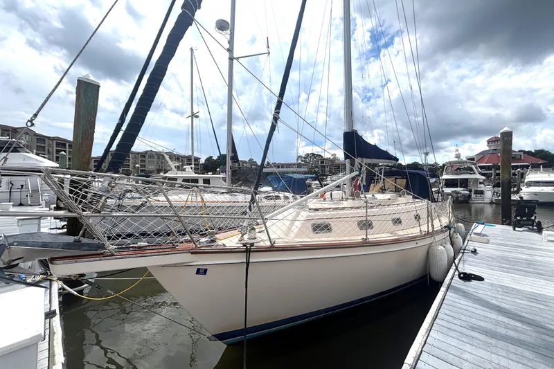 Slide: The Image of 1995 Island Packet 40 sailboat docked at a marina under a cloudy sky. - 67