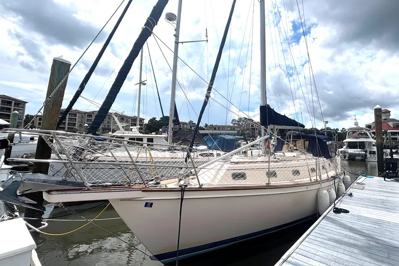 Slide: The Image of 1995 Island Packet 40 sailboat docked at a marina under cloudy skies. - 68
