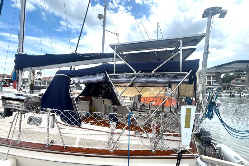 Slide: The Image of Sailboat Island Packet 40, 1995 model, docked with solar panels and blue canopy. - 70