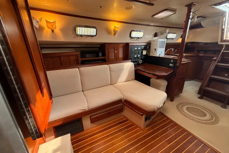 Slide: The Image of Interior of 1995 Island Packet 40 sailboat with cozy seating and wooden accents. - 8