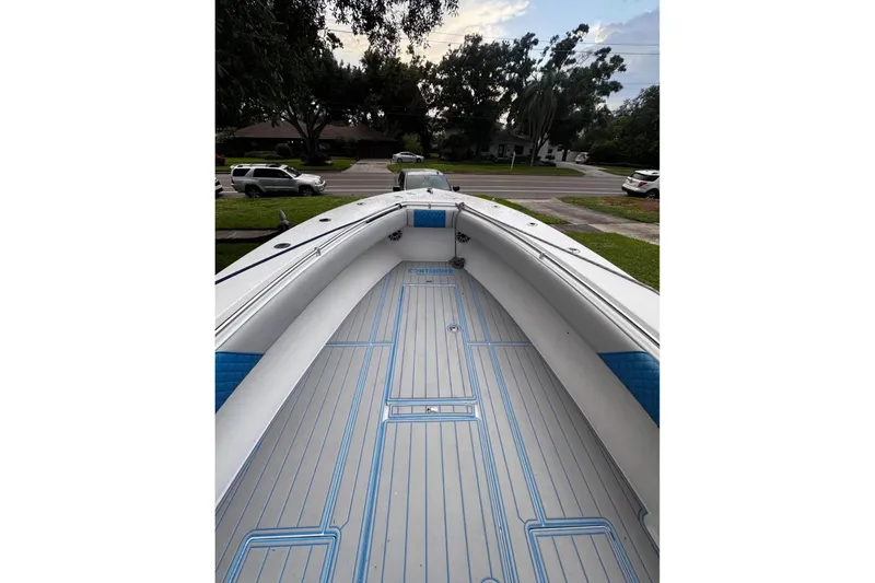 Slide: The Image of 2005 Contender 31 Open boat interior with blue accents, parked in a residential area. - 3