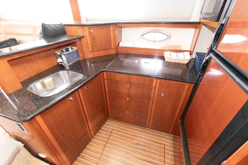 Slide: The Image of Luxurious kitchen area in a 2007 Meridian 459 Motoryacht with wood cabinetry and granite countertops. - 16