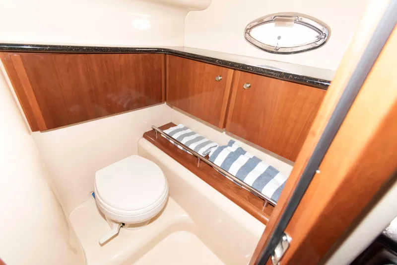 Slide: The Image of 2007 Meridian 459 Motoryacht bathroom with wooden cabinets and a porthole window. - 18